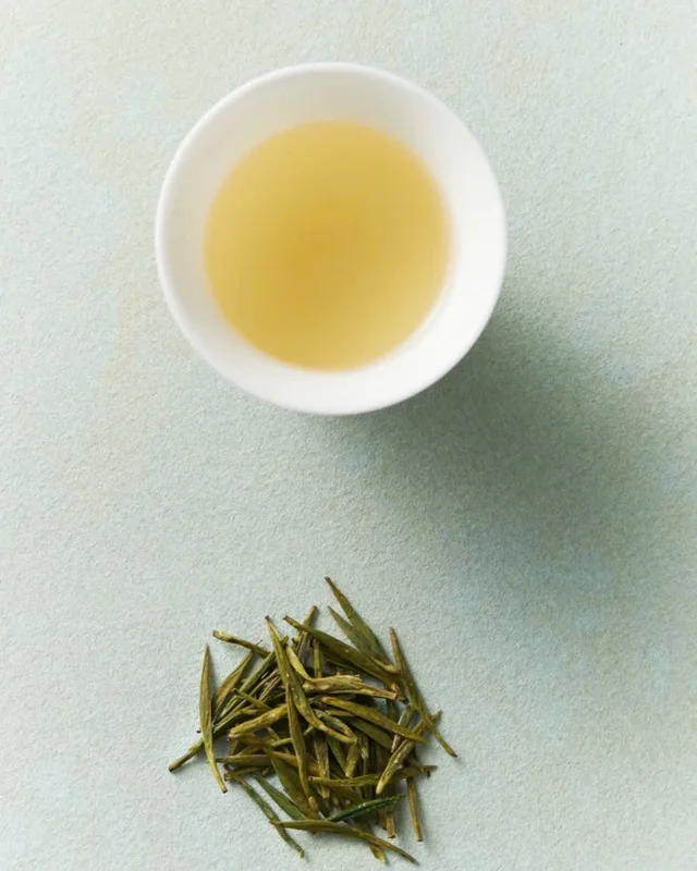 Chén trà vàng nhạt cạnh búp trà non — Viettea